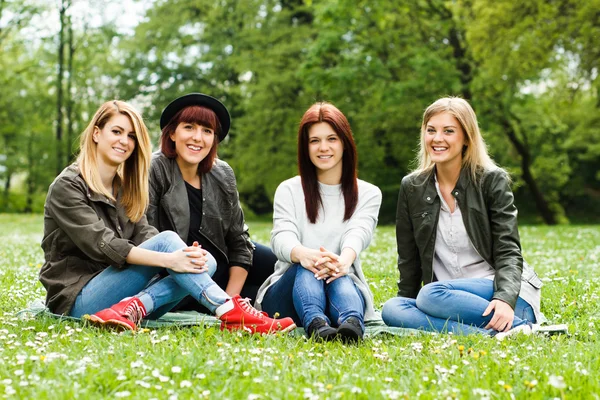 Jonge meisjes zitten in het park. Vriendschap — Stockfoto