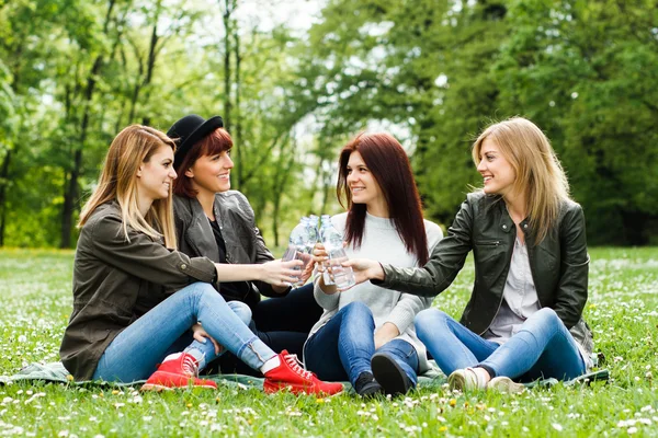 Girls are sitting in the park and drinking water — Stock Photo, Image