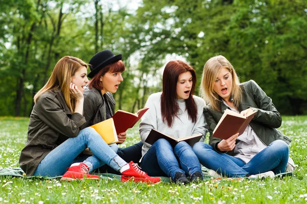 Girls are surprised because of something they had read in a book — Stock Photo, Image