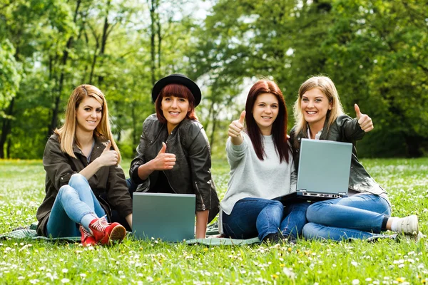 Mädchen zeigen Daumen nach oben, während sie Laptop benutzen — Stockfoto