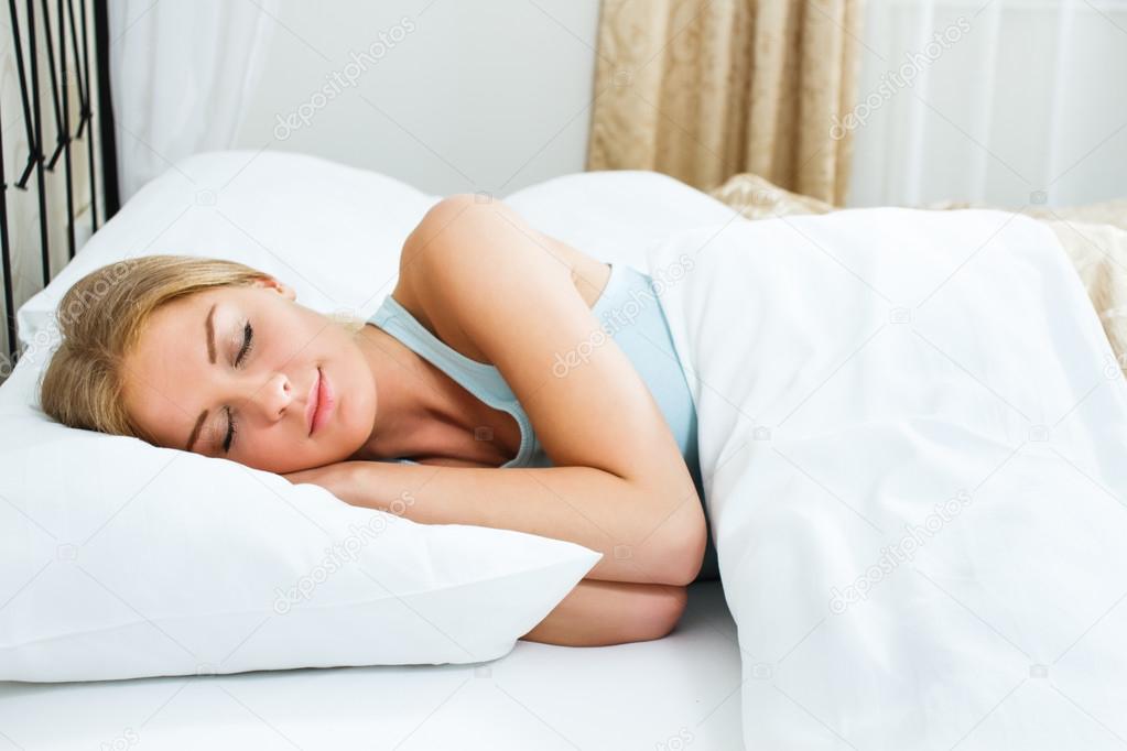 blonde woman is sleeping in her bedroom