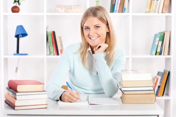 Beautiful young student with books on the table — Stock Photo, Image
