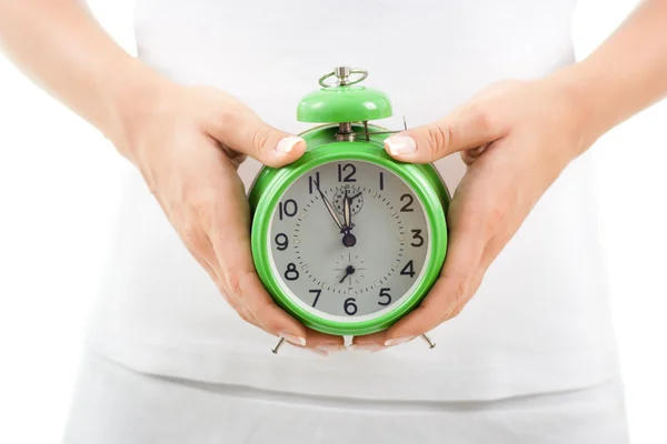 Woman holding clock on her belly — Stock Photo, Image