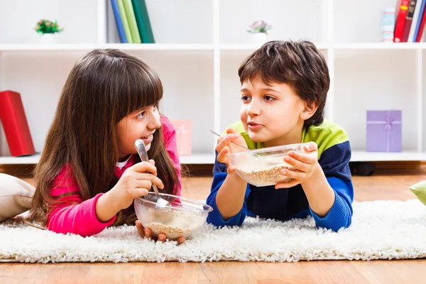 Niño y niña comiendo muesli —  Fotos de Stock