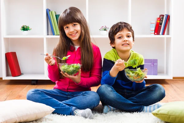 Boy and girl eating vegetables — Stock Photo, Image