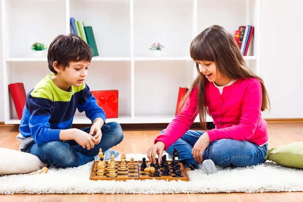 Garçon et fille jouant aux échecs — Photo