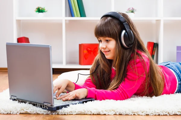 Bambina con laptop e cuffie — Foto Stock