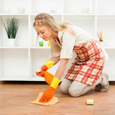 Young housewife cleaning floor