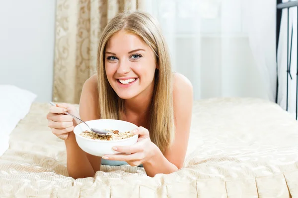 Femme au lit manger le petit déjeuner — Photo