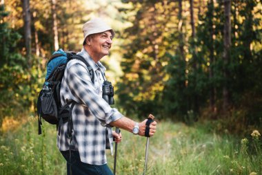 Ormanda yürüyüş yapan kaygısız son sınıf öğrencisinin portresi, aktif bir açık hava yaşam tarzının tadını çıkarıyor..