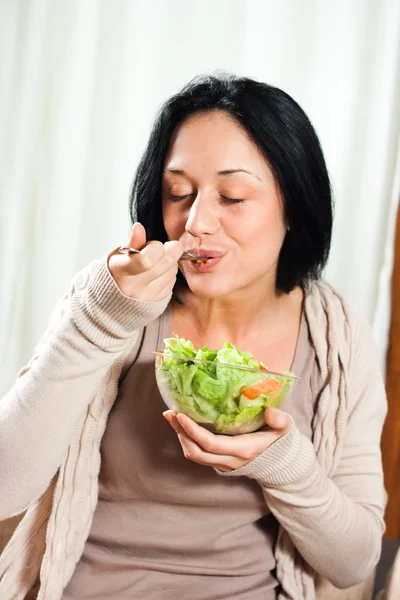 Junge Frau isst Salat — Stockfoto