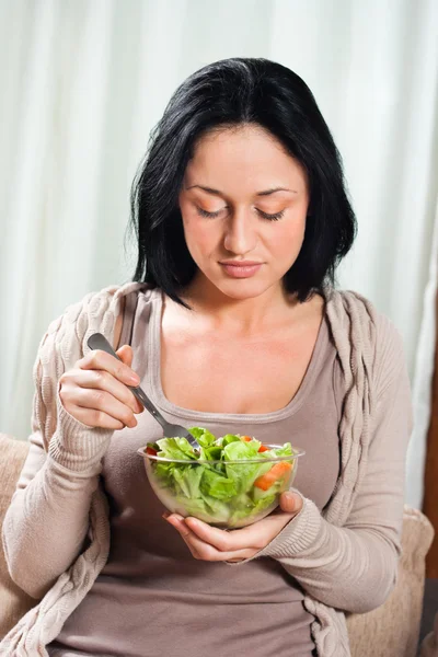 Jovem mulher comendo salada — Fotografia de Stock