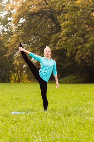Žena cvičí jógu v parku — Stock fotografie