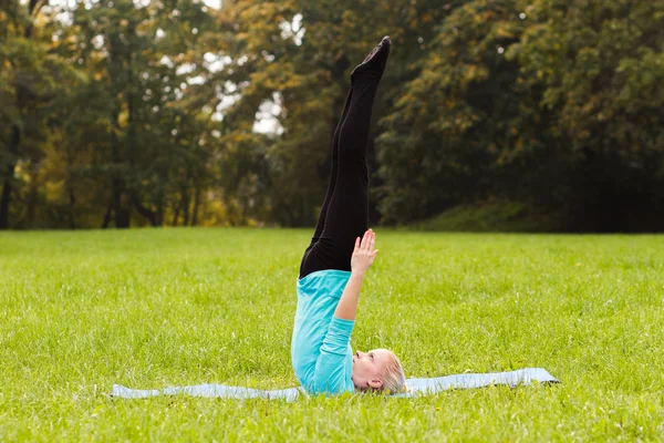 Kadın parkta yoga yapıyor. — Stok fotoğraf