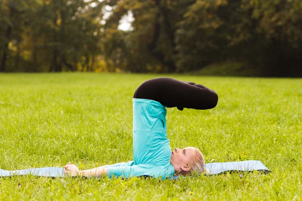 Kadın parkta yoga yapıyor. — Stok fotoğraf