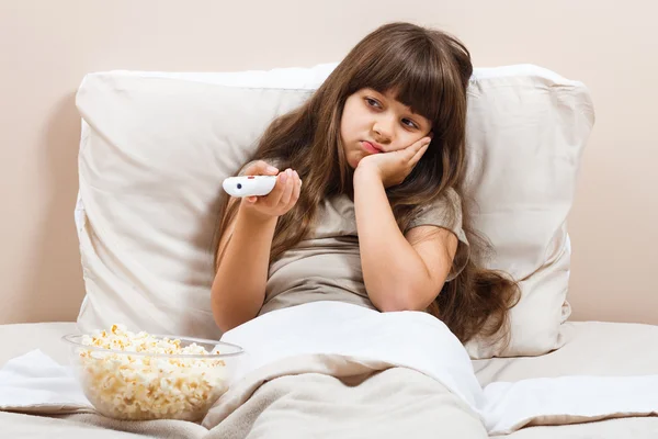 Chica en la cama viendo la televisión — Foto de Stock