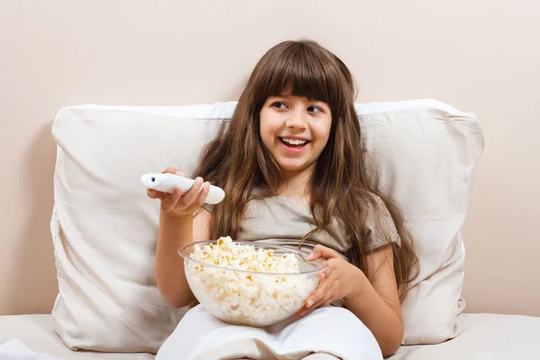 Menina na cama assistindo TV — Fotografia de Stock