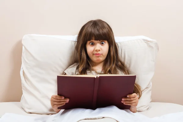 Meisje in bed lezen van boek — Stockfoto