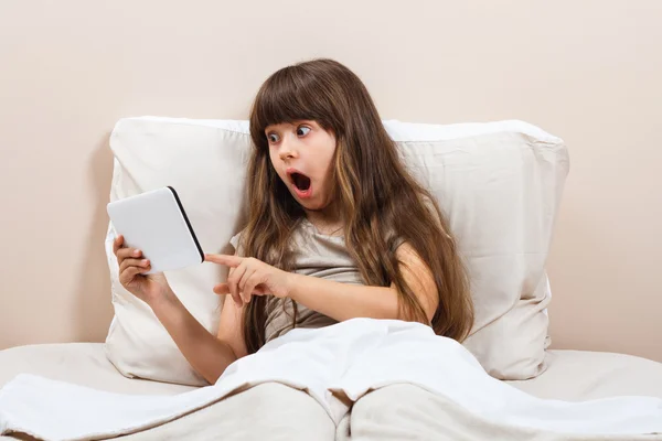 Menina na cama usando tablet — Fotografia de Stock