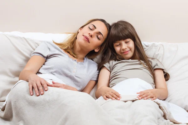 Mãe e filha dormindo na cama — Fotografia de Stock