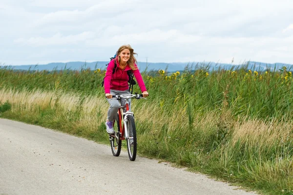 Young woman riding bicycle — Stock Photo, Image