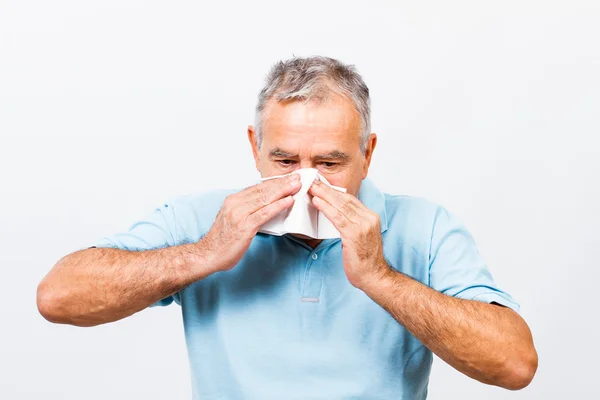 Senior man blowing noze — Stock Photo, Image