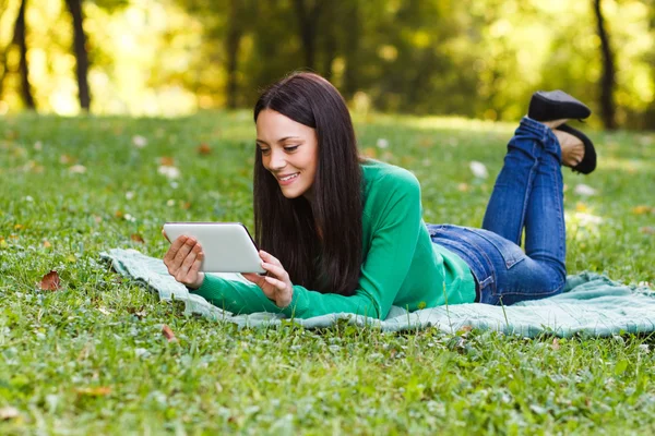 Mulher no parque usando tablet — Fotografia de Stock