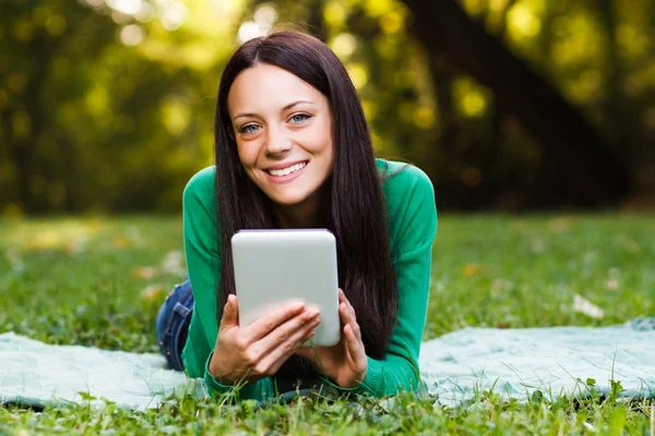 Kvinna i parken med hjälp av Tablet PC — Stockfoto