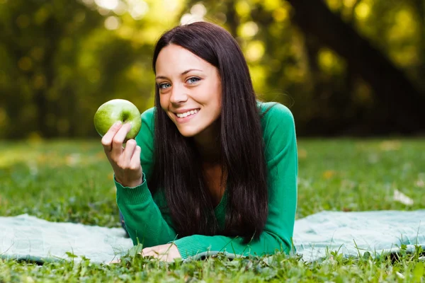 Γυναίκα στο πάρκο διατροφικές μήλο — Φωτογραφία Αρχείου