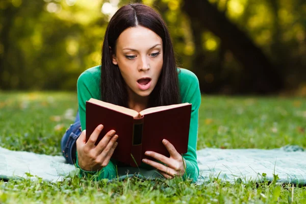 Frau im Park liest Buch — Stockfoto