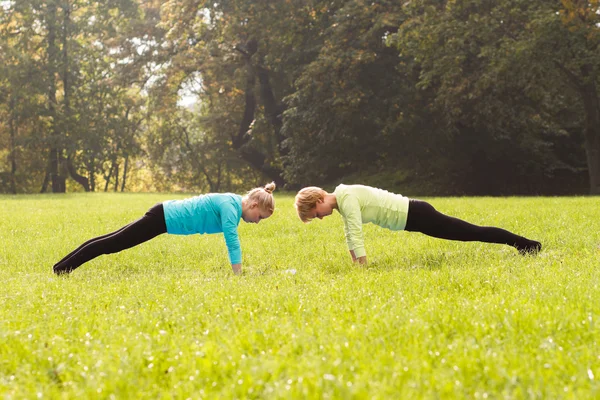 Amigos praticando ioga no parque — Fotografia de Stock