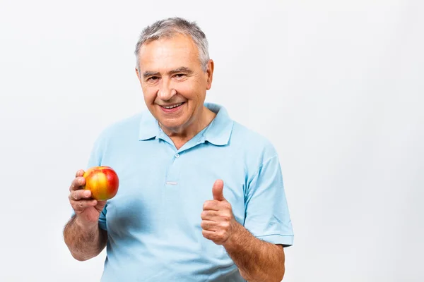 Senior man eating apple — Stock Photo, Image