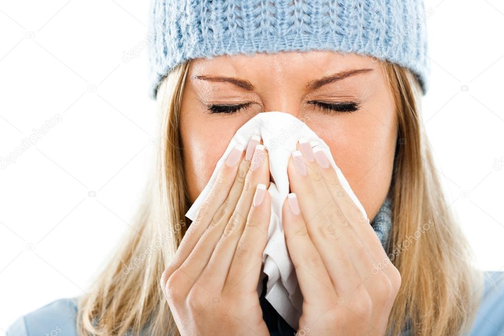 Woman is sneezing into handkerchief