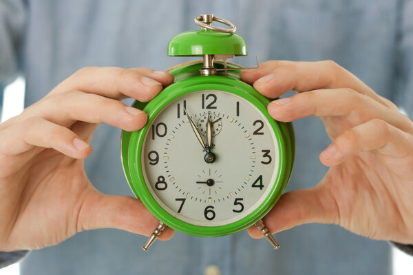 man hands holding clock