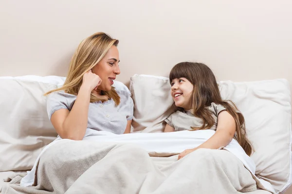 Anne ve kızı yatağa konuşuyor — Stok fotoğraf
