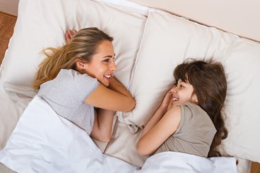 Anne ve kızı yatakta dinleniyor