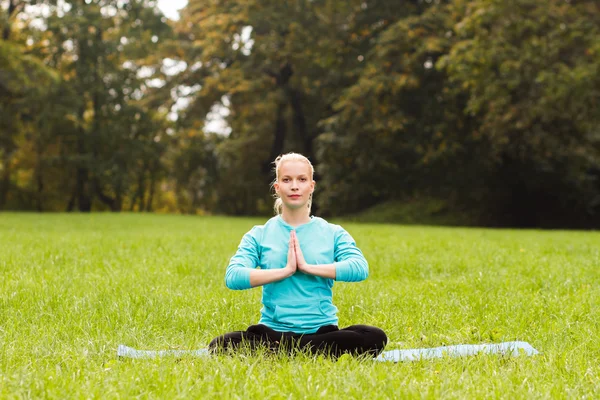 Kadın parkta yoga yapıyor. — Stok fotoğraf