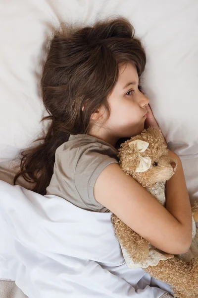 Маленькая девочка лежит в постели — стоковое фото