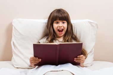 Küçük kız kitap okuyor.