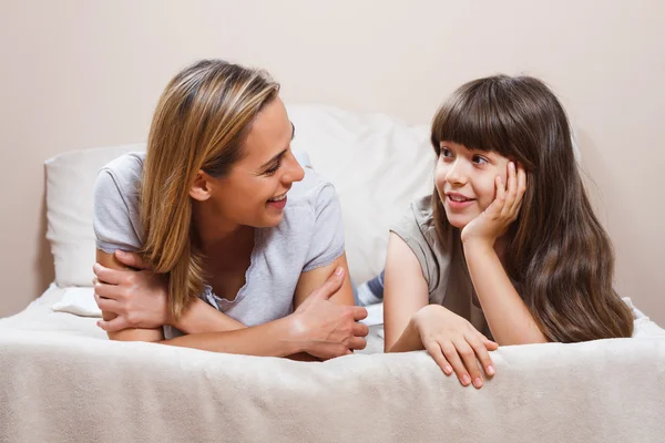 Moeder en dochter praten op bed — Stockfoto