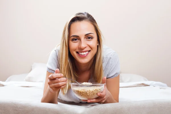 Γυναίκα στο κρεβάτι που τρώει πρωινό — Φωτογραφία Αρχείου