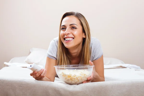 Woman watching tv on bed — Stock Photo, Image