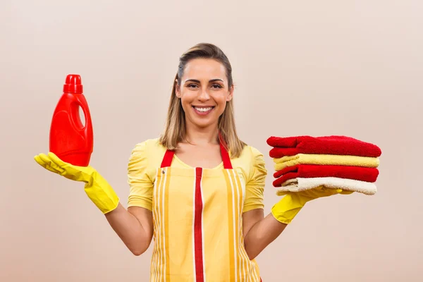 Jovem dona de casa com detergente e lavanderia — Fotografia de Stock