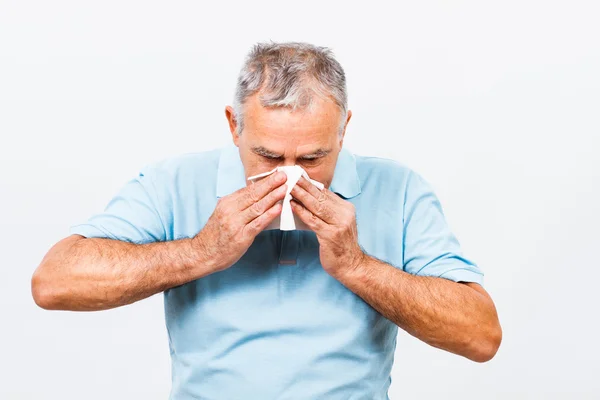 Senior man blowing his nose — Stock Photo, Image