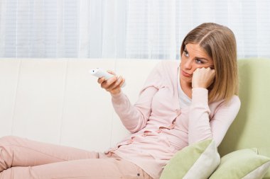 Evde televizyon izleyen bir kadın.