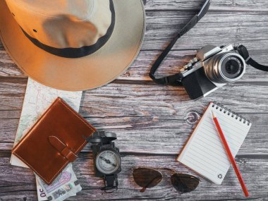 Seyahat konsepti, şapka, cüzdan, bilet, harita, not defteri, fotoğraf makinesi, kalem, pusula, gözlük.