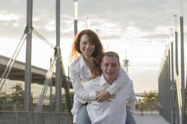 Açık havada şehirde sırtında taşıyan kız adam