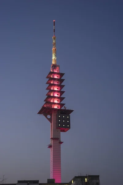 Hannover, Germany - March 19, 2015: Telecommunication tower Telemax in Hannover. The tower is illuminated in magenta, the corporate color of Deutsche Telekom, for the CeBit. — Stock Photo, Image
