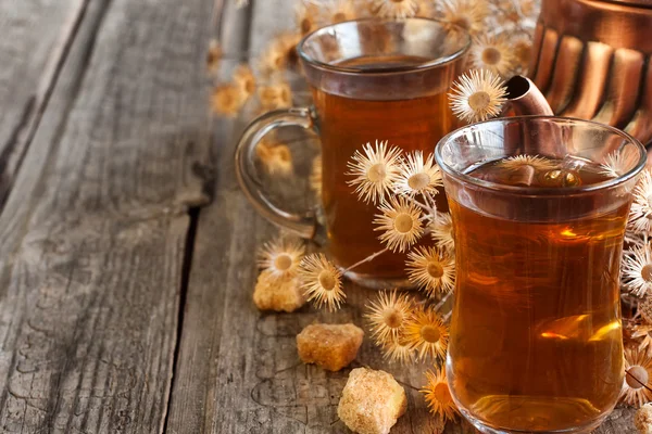 Tea és a száraz virágok háttér — Stock Fotó