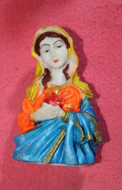 Pembe arka planı olan neşeli bir heykel. Meryem, Hz. İsa 'nın annesi ve Yusuf' un karısı, Nasıralı birinci yüzyılda yaşamış bir Yahudi kadındır..